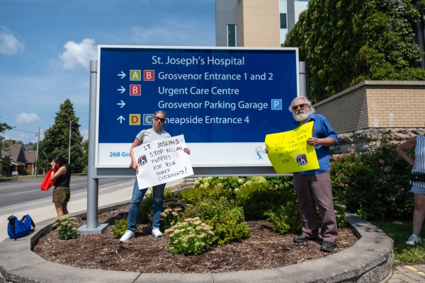 Two supporters holding signs outside St Joseph's Hospital