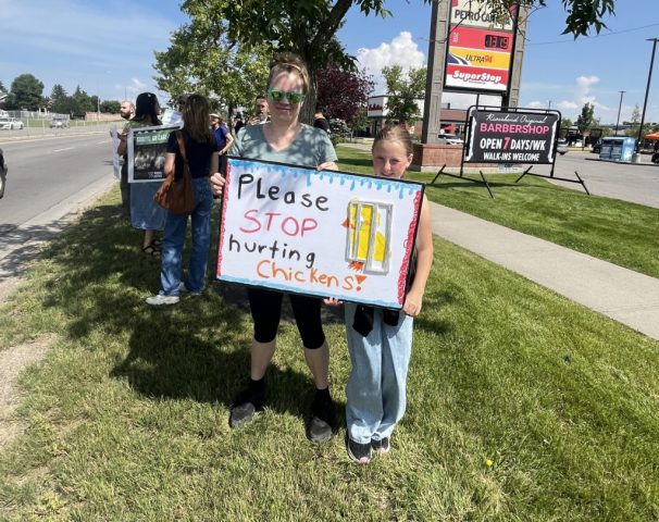 Supporters with sign: Please STOP hurting Chickens