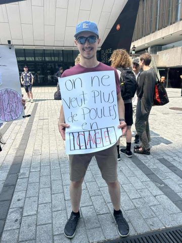 Supporter with Sign: On ne veut plus de poules en cage (we don't want hens in cages)